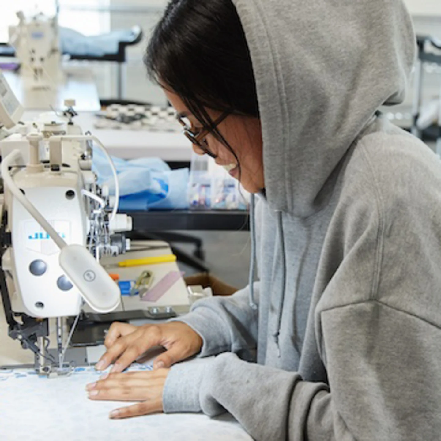 person sewing fabric with sewing machine