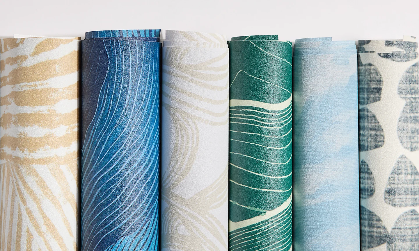 Rolls of abstract vinyl wallpaper designs.