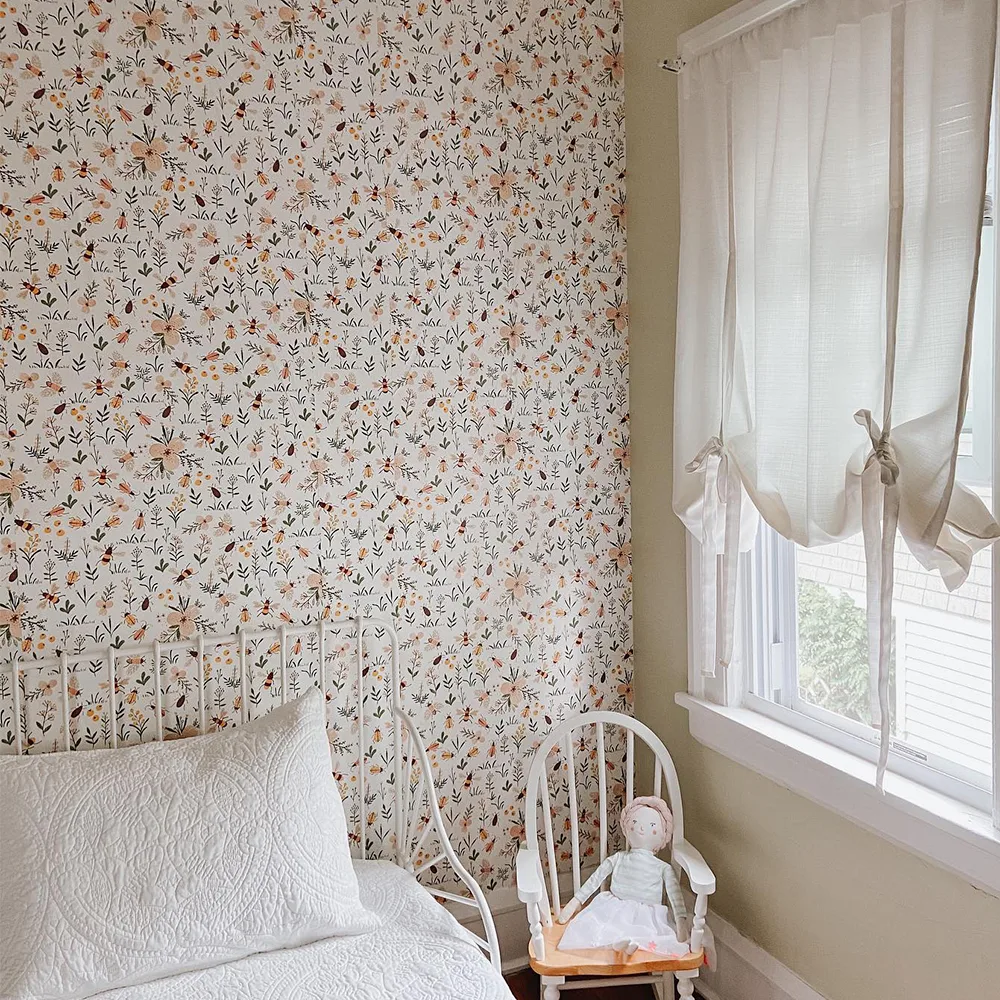 Floral wallpaper with bees in a child's bedroom.