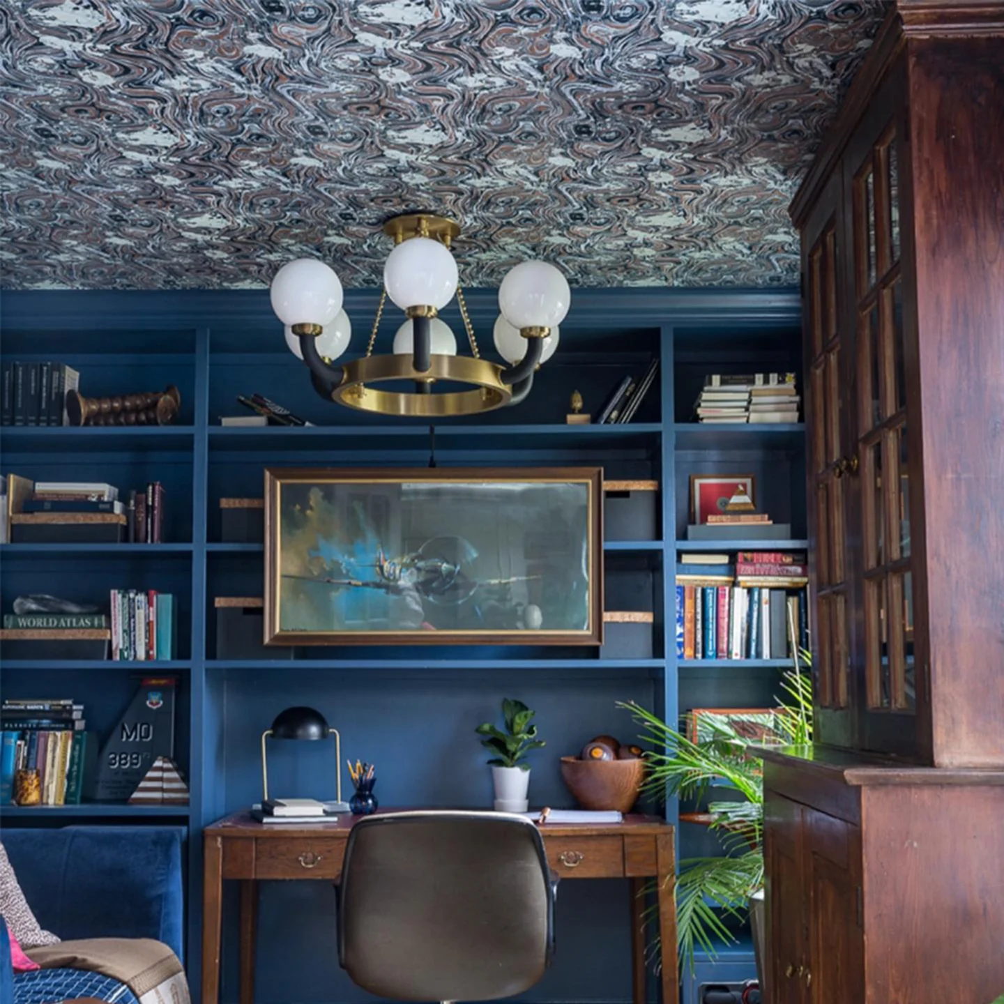 Blue orange marbled wallpaper on a ceiling of a home office.