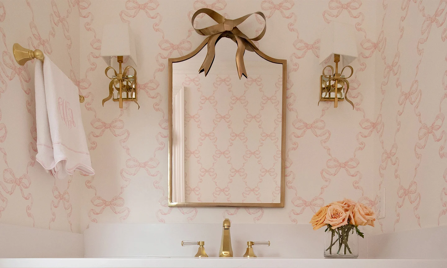 Bathroom with pink bow wallpaper.