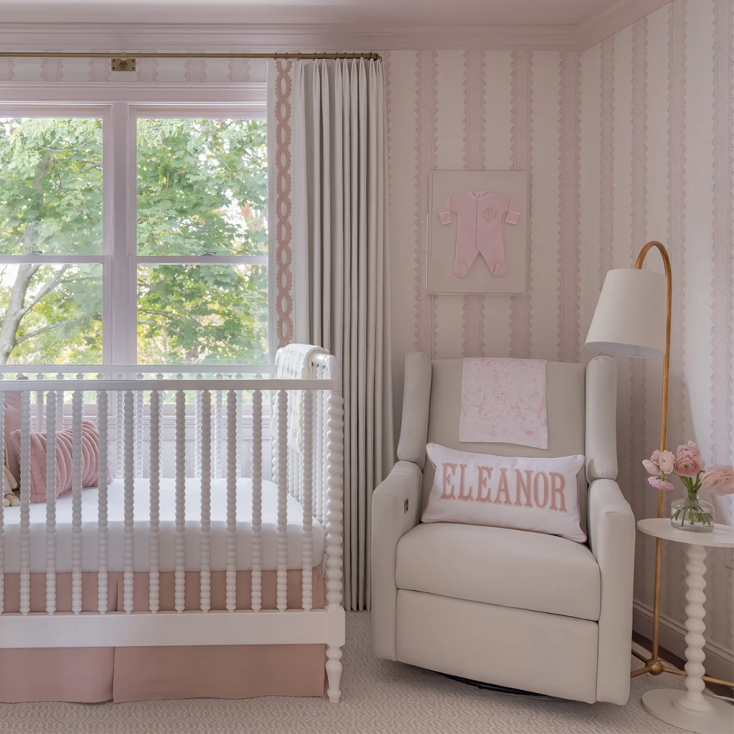 Nursery with pink stripe wallpaper and a crib.