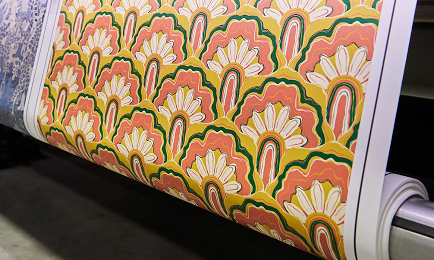 Roll of orange wallpaper designed by Dani Dazey being printed in a Spoonflower manufacturing facility.