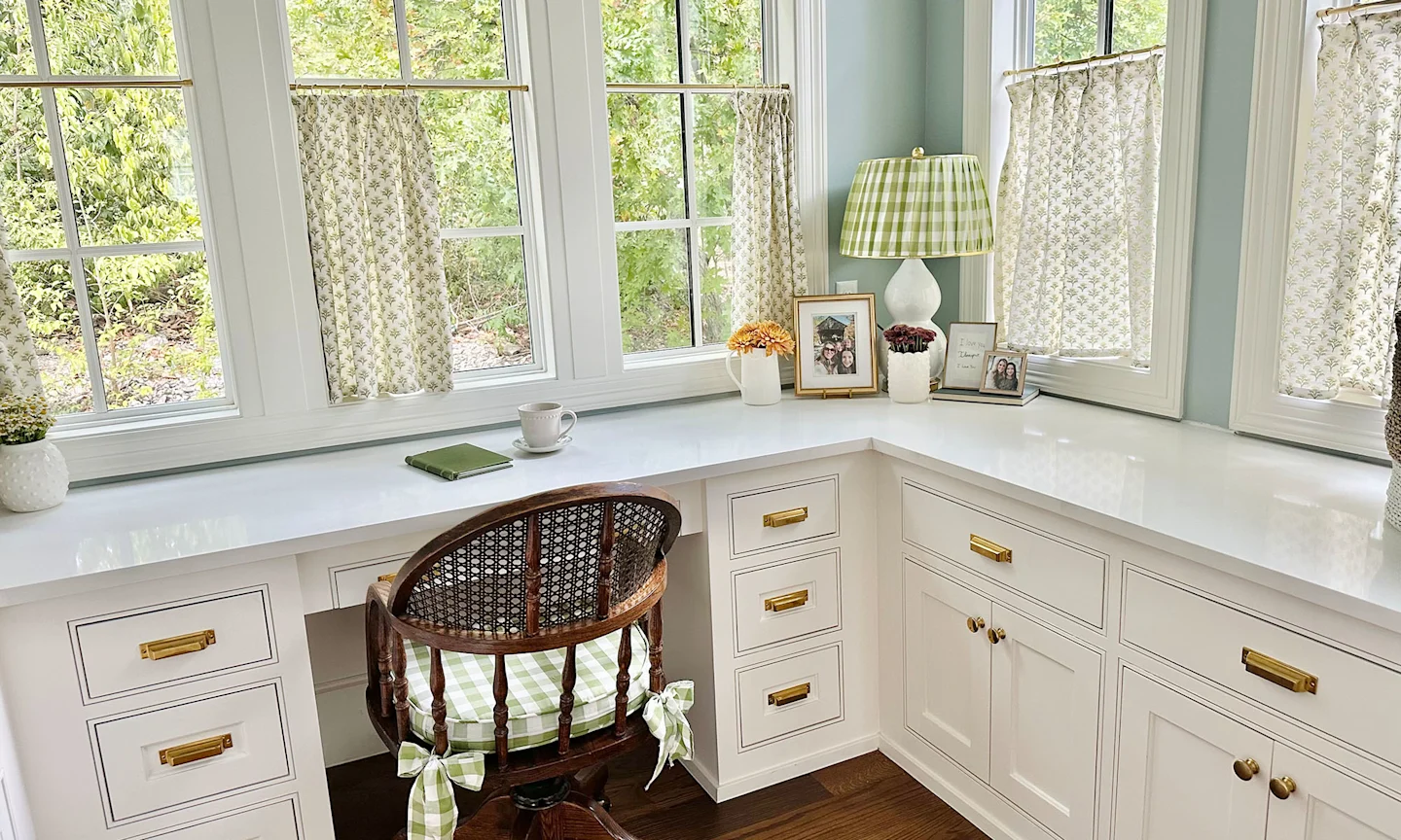 Home office space with block printed cafe curtains and coordinating gingham lampshade, chair cushion and ceiling wallpaper.