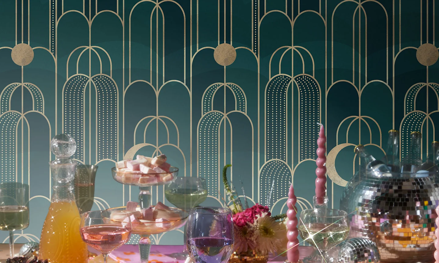 A luxurious New Years Eve tablescape with glamorous teal Art Deco wallpaper