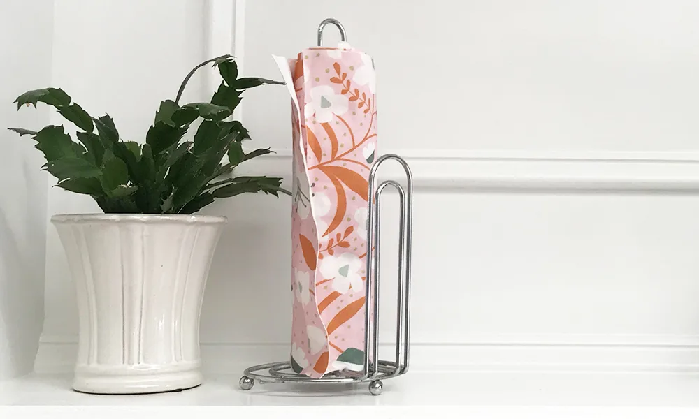 Final roll of the no-sew DIY reusable and washable fabric paper towels on paper towel roll holder in a kitchen.