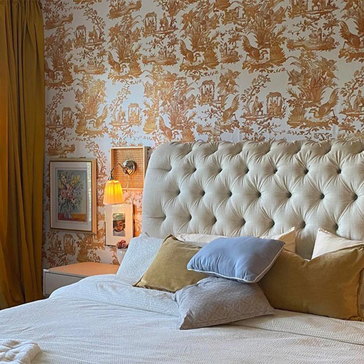Gold toile wallpaper behind bed.