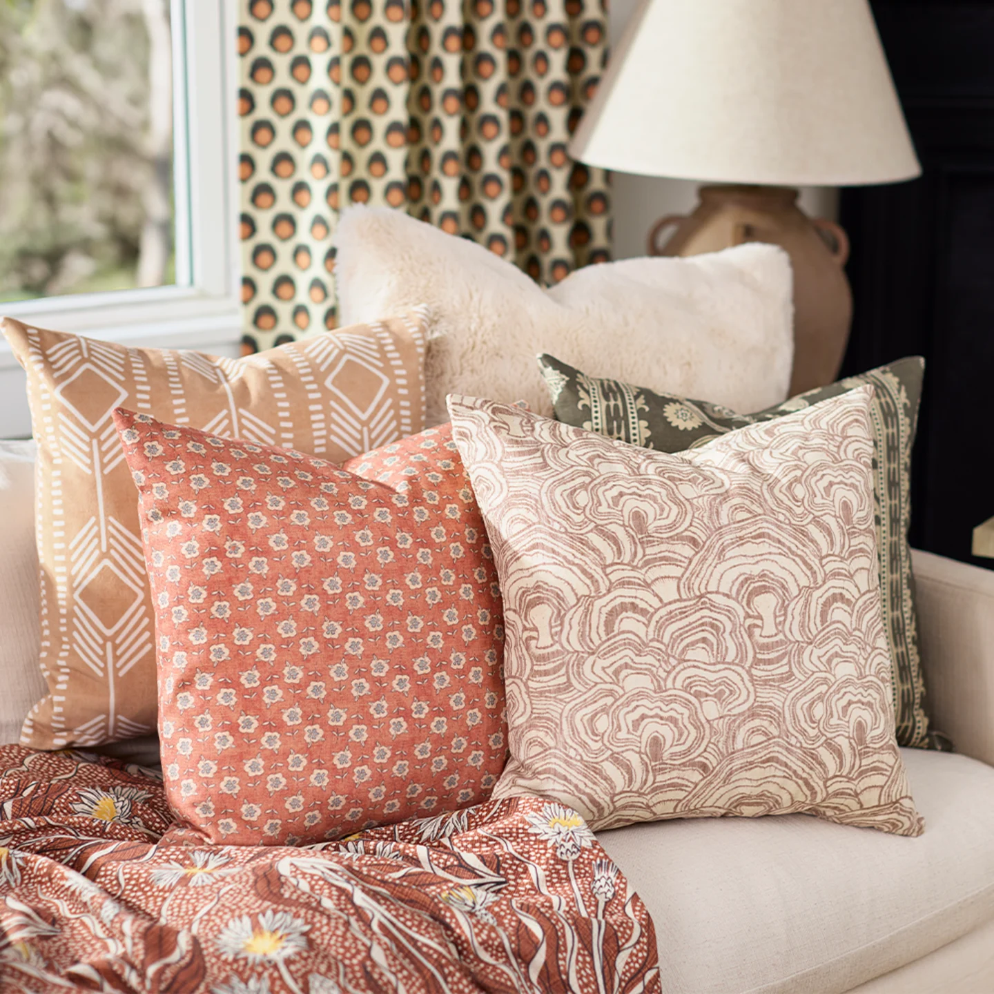 Neutral throw pillows stacked on a sofa